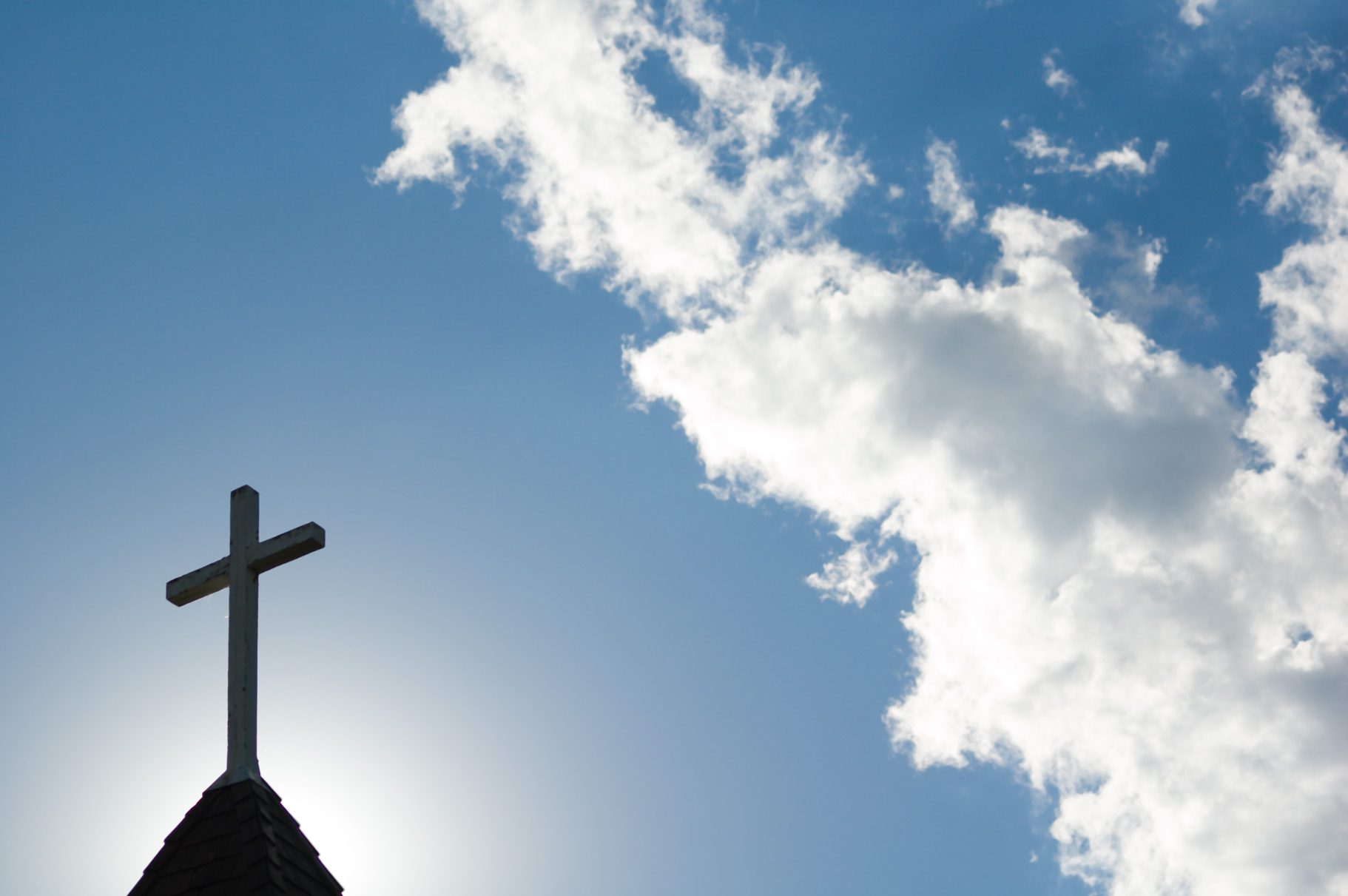 An old church steeple backlit by a low setting sun. (iStock)